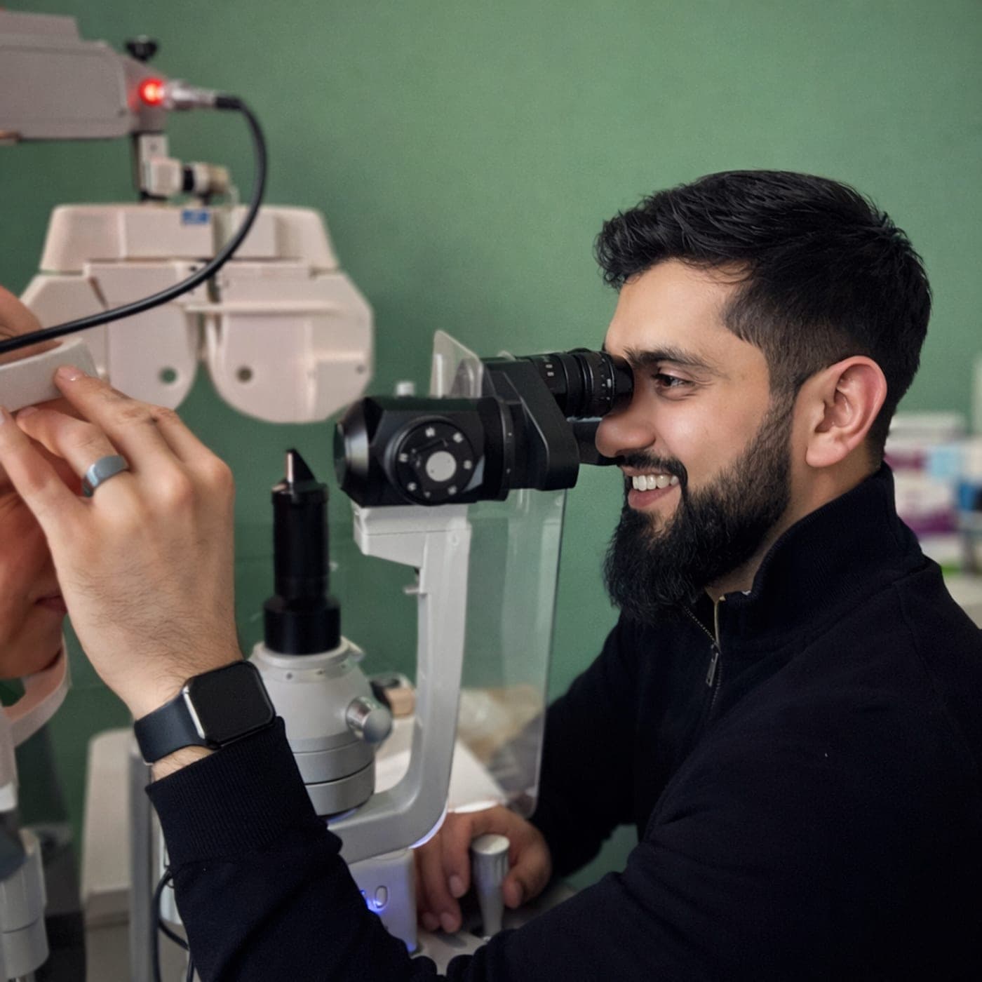 Adail Islam examining a patient at a slit lamp